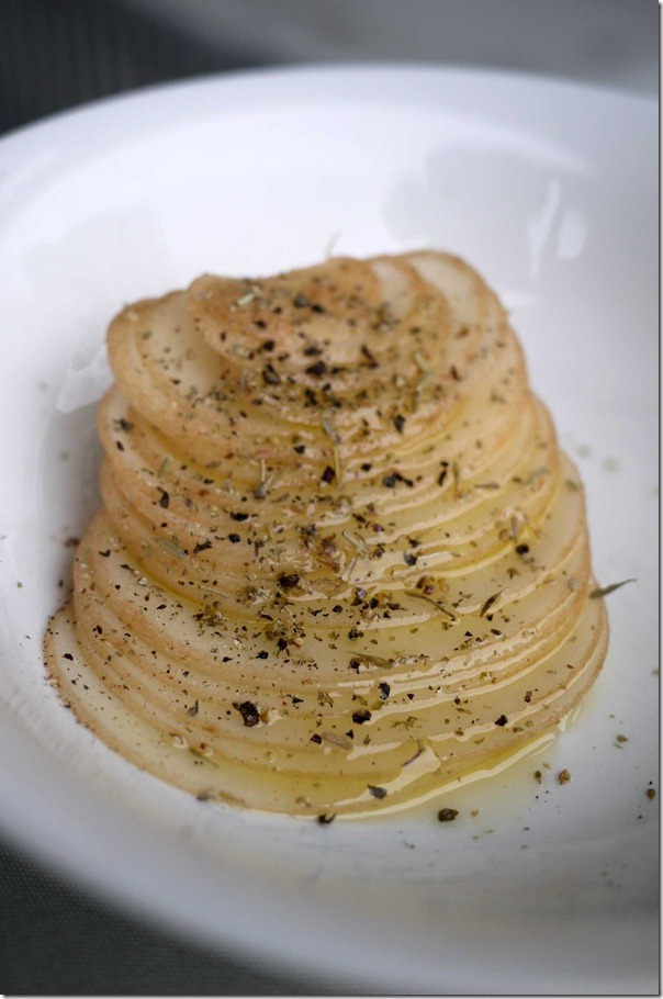 Mandolin potato sliced sprinkled with dried herbs, salt, black pepper and drizzled with extra virgin olive oil
