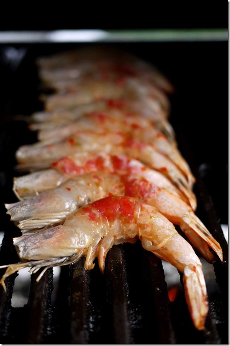 Grilling prawns marinated with salt and fresh red chilli paste
