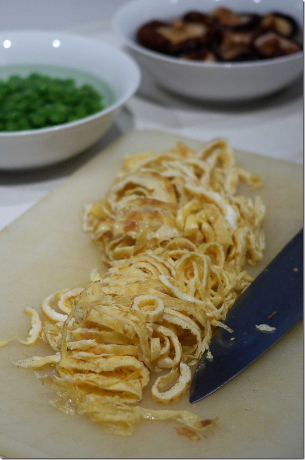 Roll up omelette and slice into thin strips of stringy egg