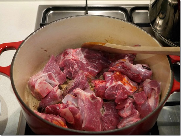Searing fresh goat meat in cast iron pot